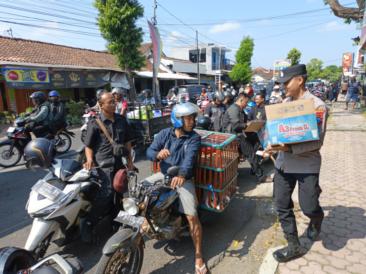Polisi Peduli : Polres Bondowoso Berbagi Air Minum kepada Warga yang Antri di SPBU
