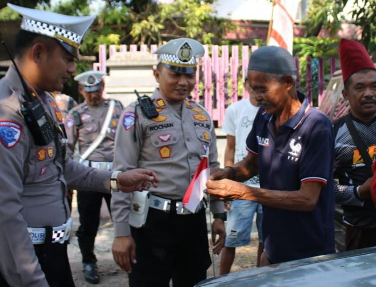 Polisi Gelorakan Semangat Nasionalisme Ratusan Bendera Merah Putih Dibagikan untuk Pengemudi di Bondowoso